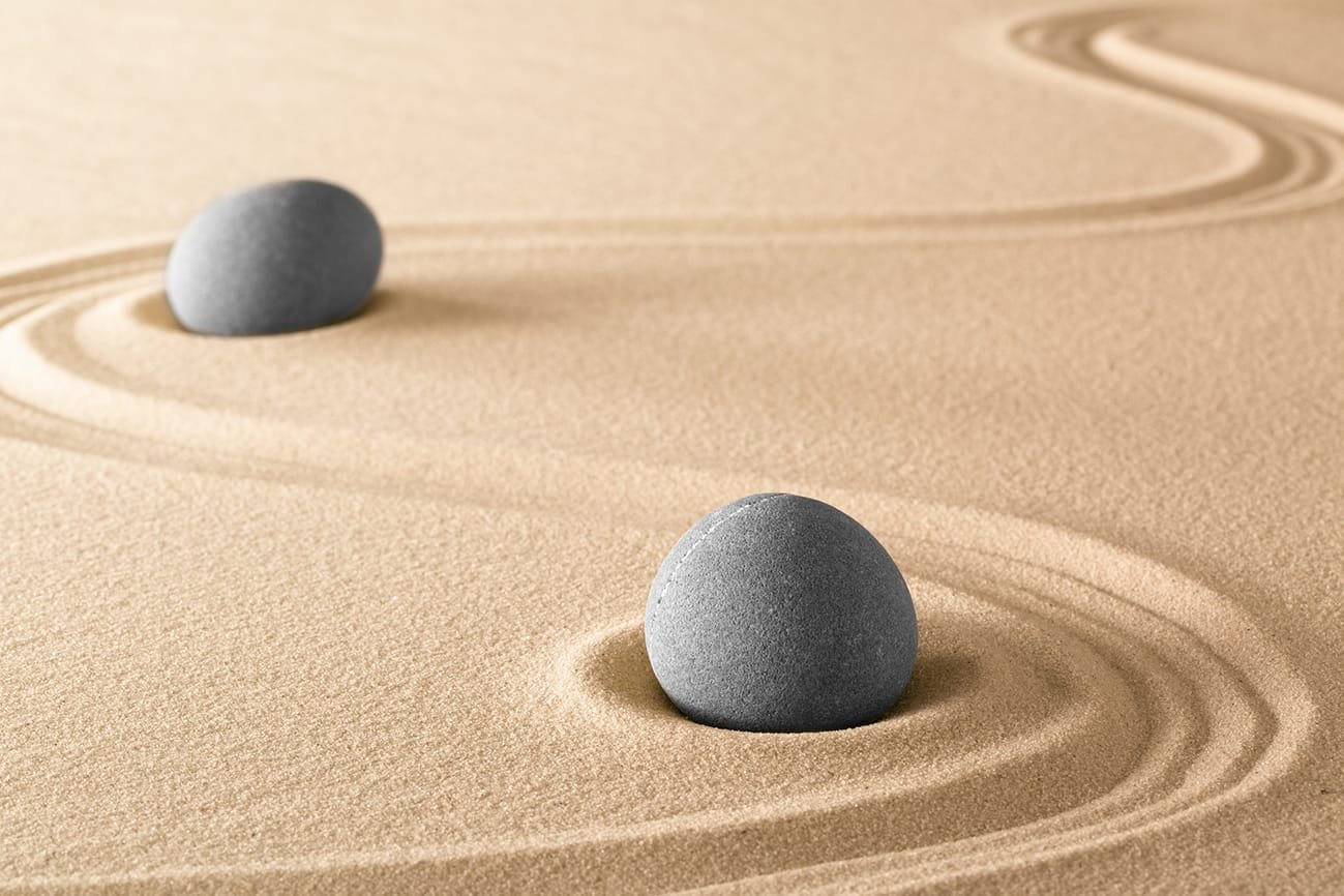 zen stones and lines in sand of Japanese garden. Spa wellnes the quieora logo